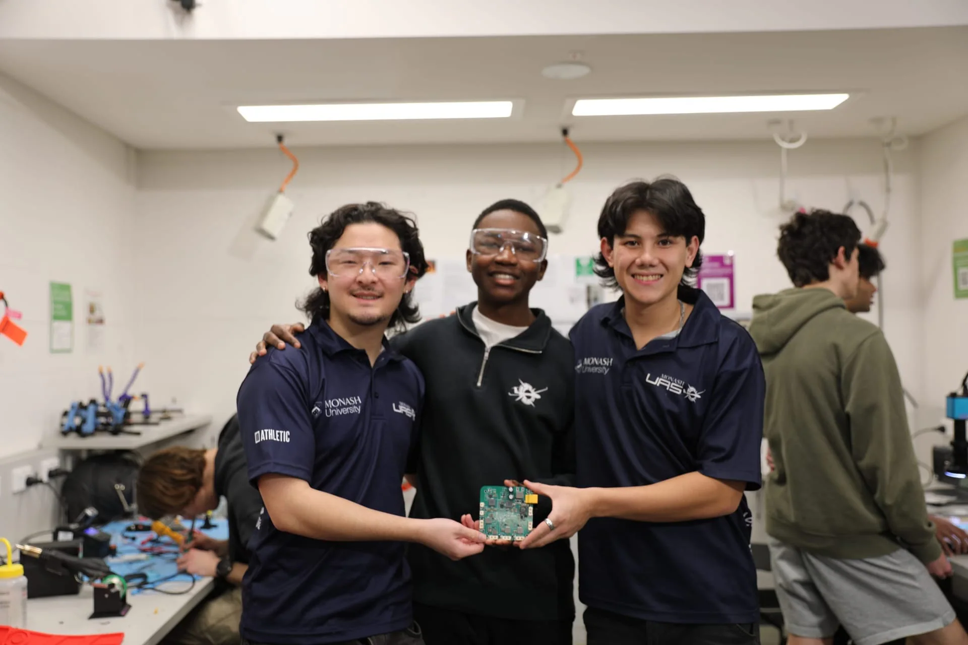 Avionics members holding a circuit board